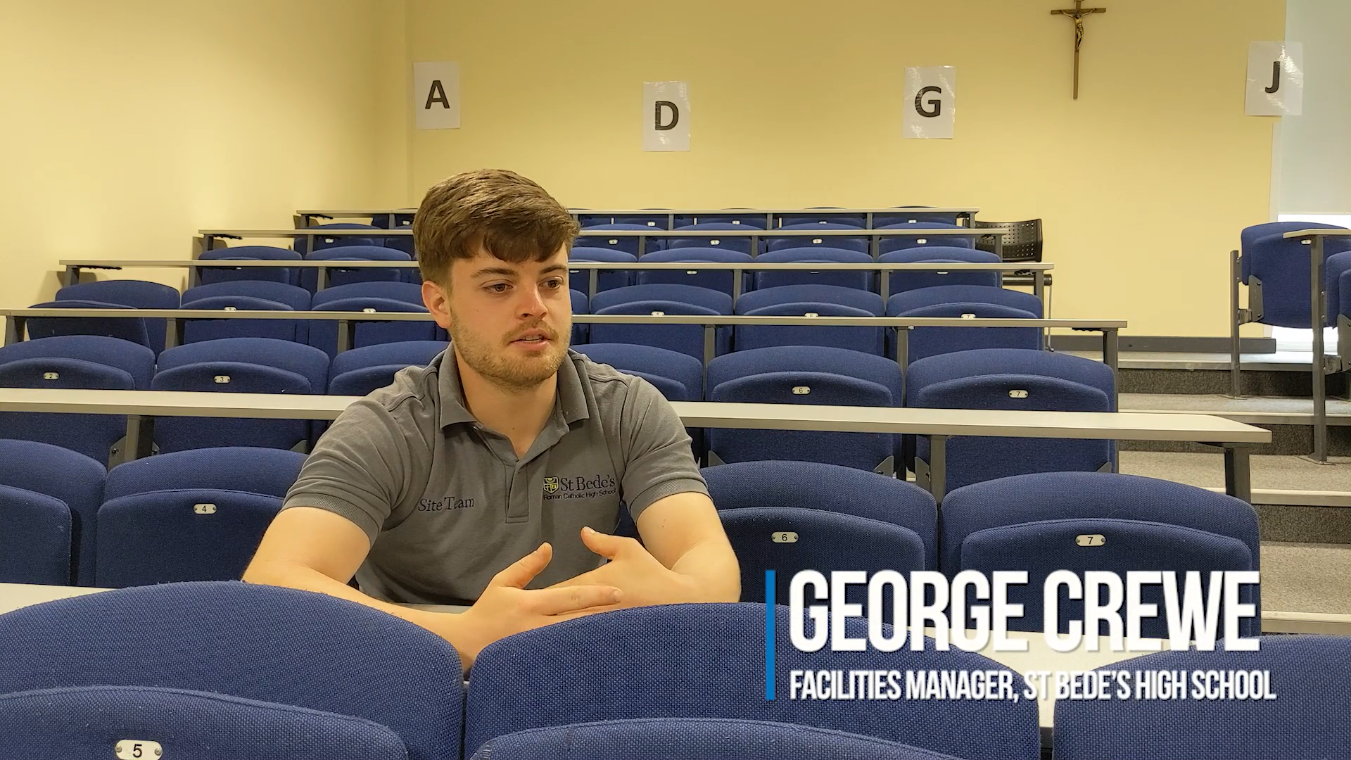 George Crewe, Facilities Manager at St Bedes Catholic School, speaking about the Audiebant system installation, seated in the lecture hall.