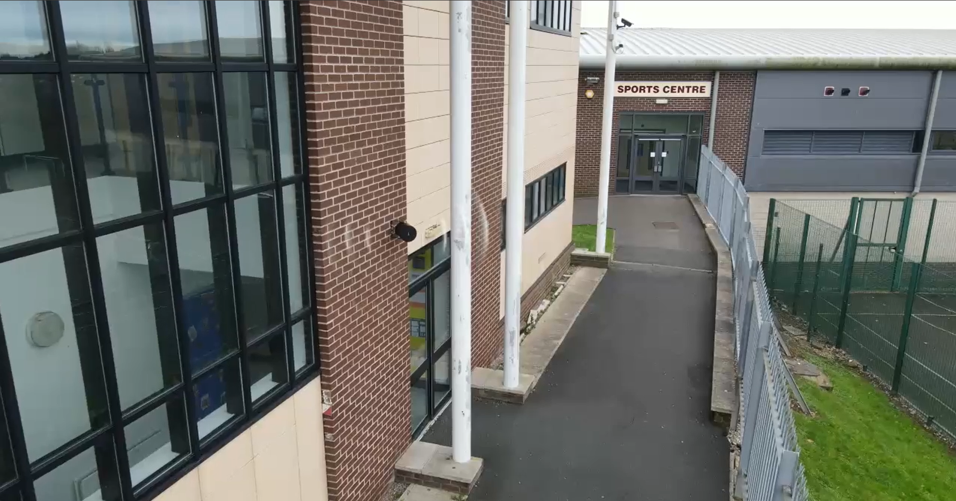 An external speaker mounted on the wall outside the sports centre.